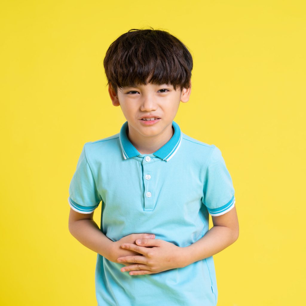 portrait of an asian boy posing on a yellow background